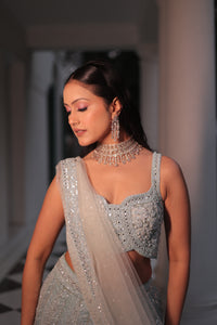 AQUA BLUE NET LEHENGA EMBELLISHED WITH SEQUINS,CUT DAANA AND A TOUCH OF MIRROR WORK