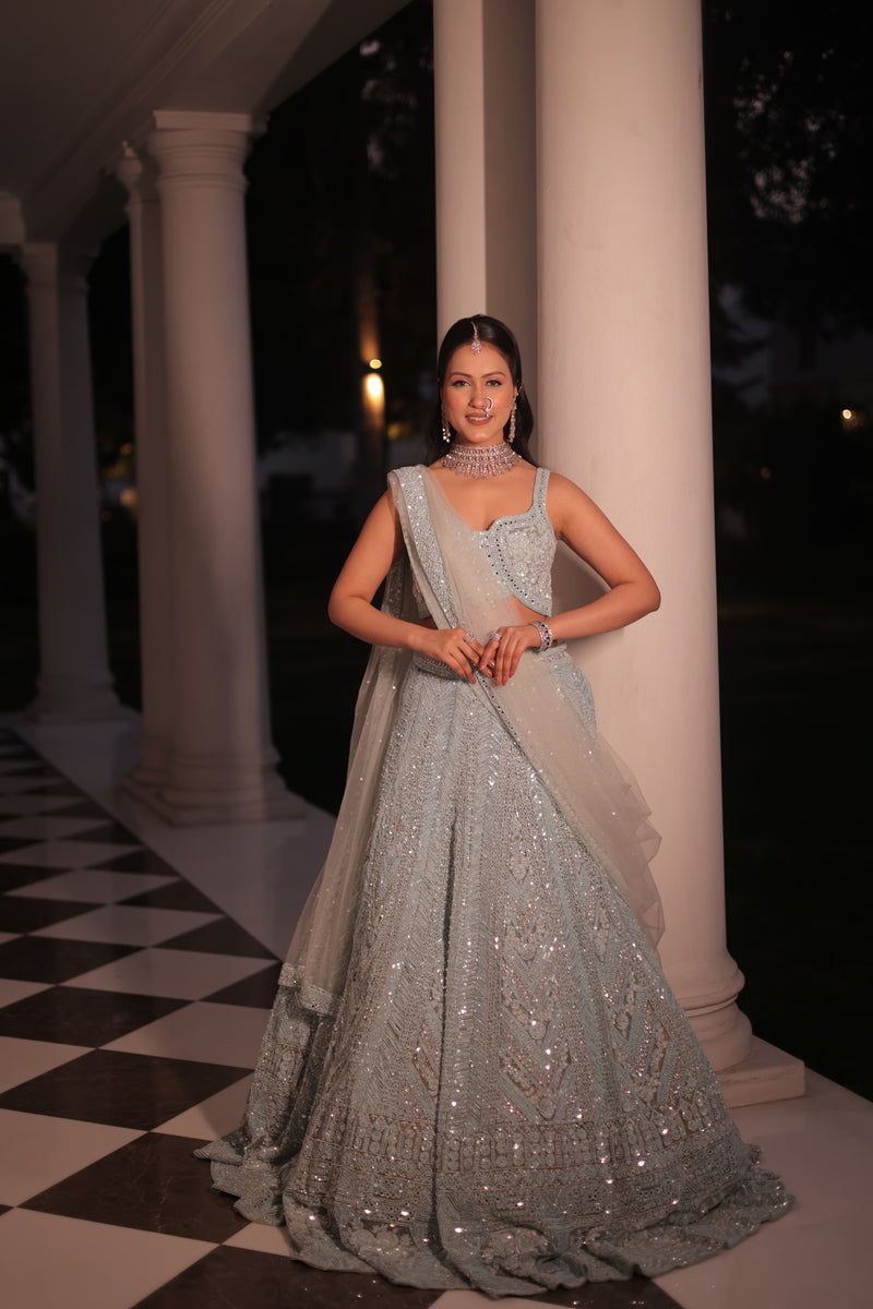 AQUA BLUE NET LEHENGA EMBELLISHED WITH SEQUINS,CUT DAANA AND A TOUCH OF MIRROR WORK