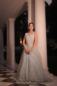 AQUA BLUE NET LEHENGA EMBELLISHED WITH SEQUINS,CUT DAANA AND A TOUCH OF MIRROR WORK