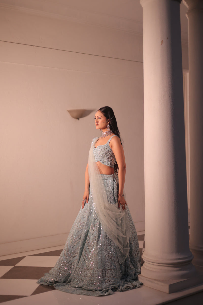AQUA BLUE NET LEHENGA EMBELLISHED WITH SEQUINS,CUT DAANA AND A TOUCH OF MIRROR WORK